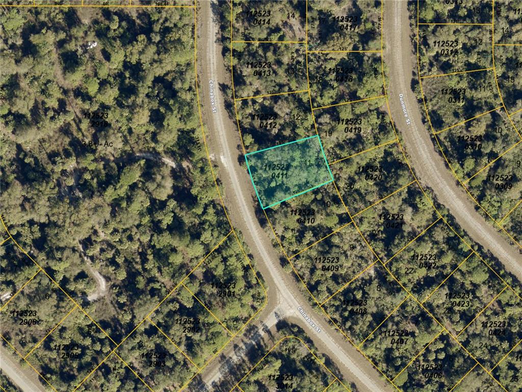 This is a satellite map showing a highlighted parcel of land among wooded lots — Lot 11 CHINABOX STREET, NORTH PORT, FL