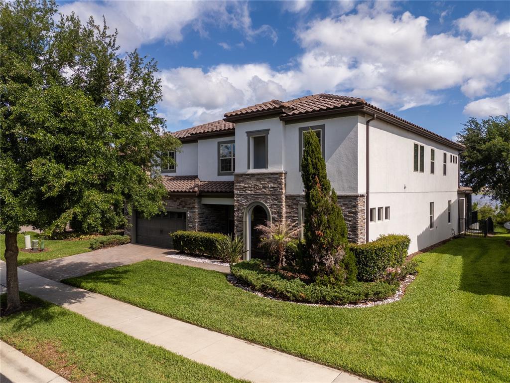 A two-story house with a stucco and stone facade, tile roof, and attached garage — 11142 LEMON LAKE BOULEVARD, ORLANDO, FL
