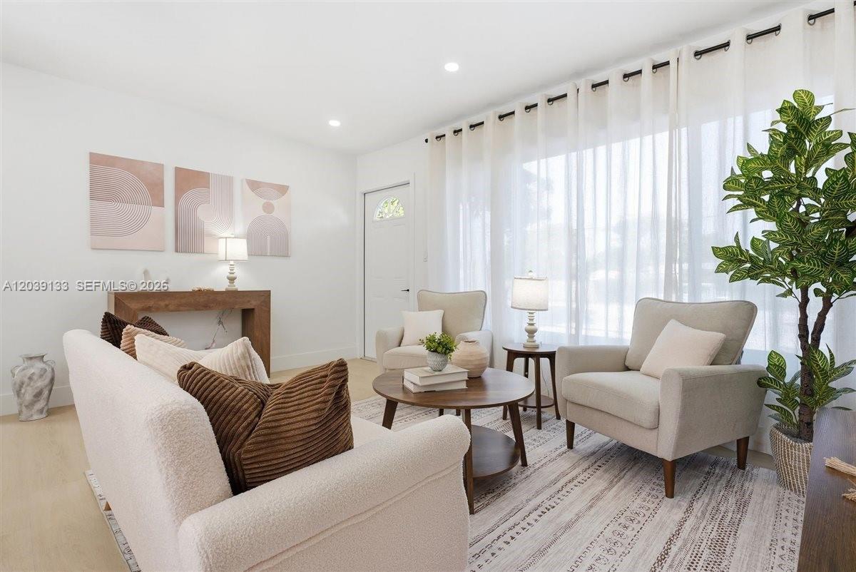 A bright living room features a sofa, two armchairs, a coffee table, and sheer curtains — 4410 NE 3rd Ave, Deerfield Beach FL 33064, DEERFIELD BEACH, FL