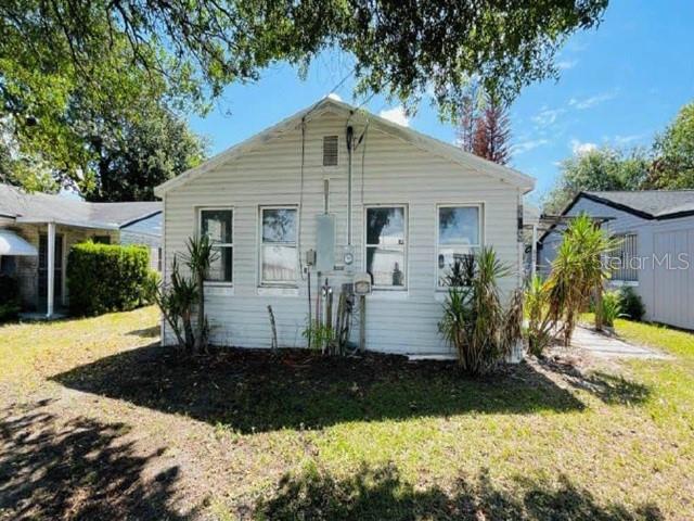 A light-colored, single-story house with white siding and a gabled roof stands on grass — 235 MCKEAN STREET, AUBURNDALE, FL