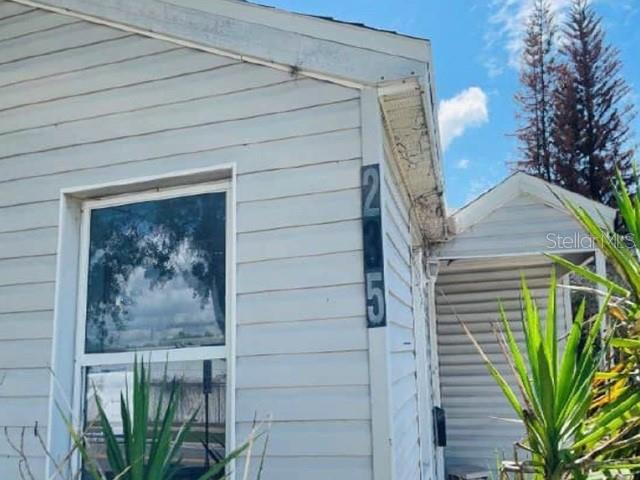 A white-sided house exterior features a window and vertical house numbers on the corner — 235 MCKEAN STREET, AUBURNDALE, FL