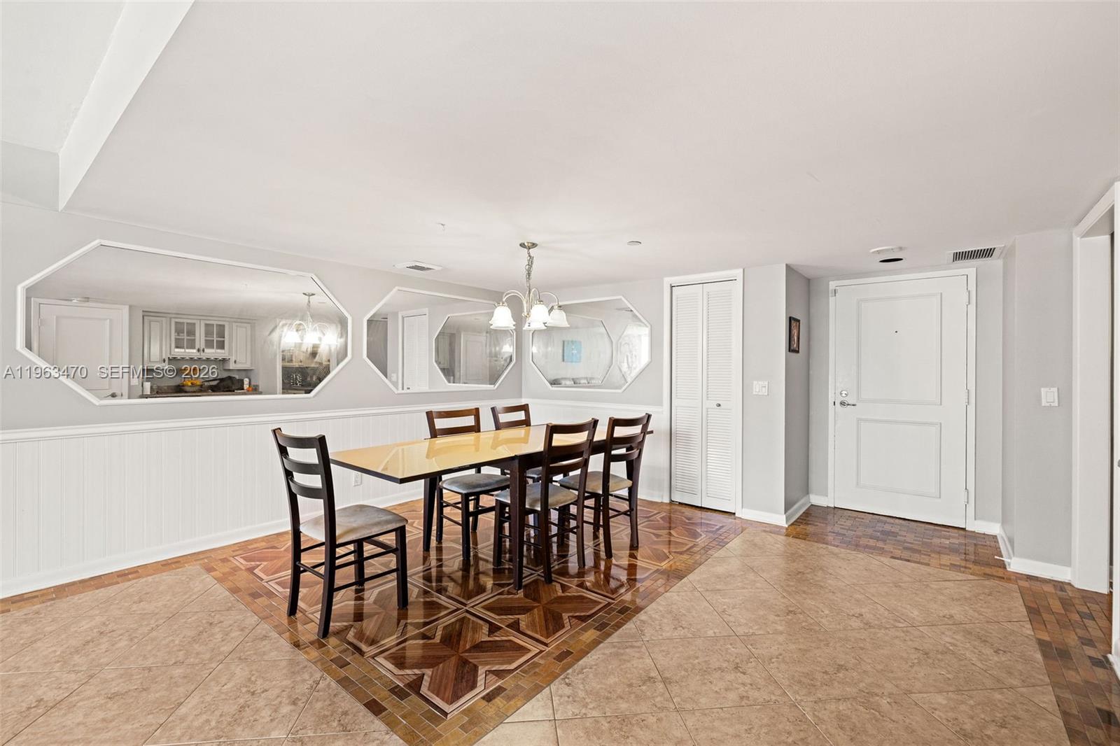A dining room features a wooden table, six chairs, wall mirrors, and patterned tile flooring — 4201 N Ocean Blvd # 208, Boca Raton FL 33431, BOCA RATON, FL