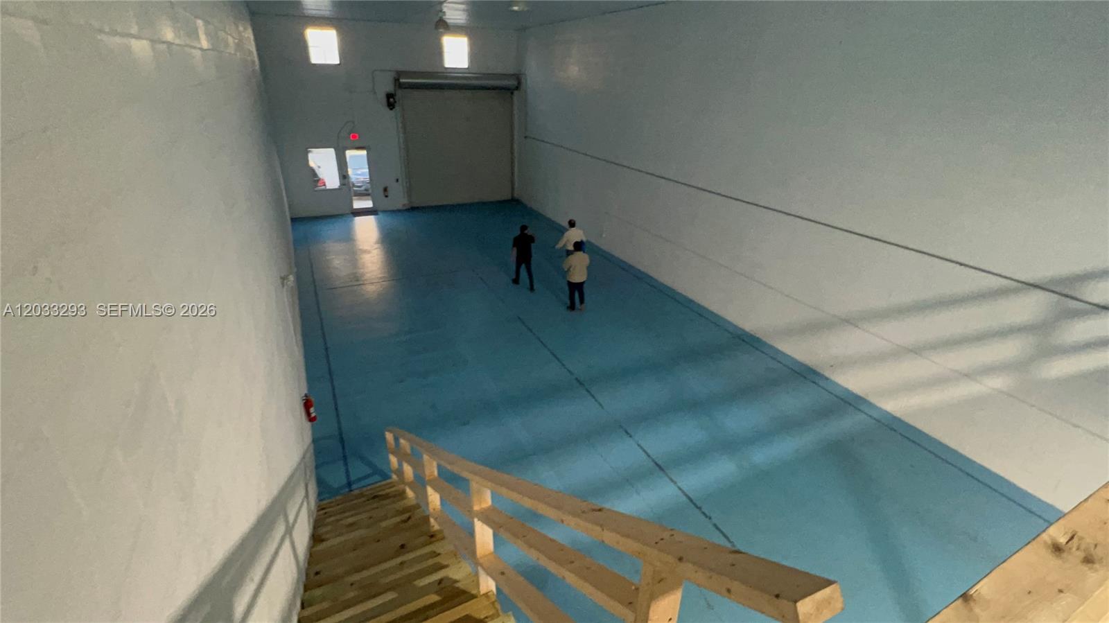 An elevated view shows a large warehouse with blue floors, white walls, and wooden stairs — 1118 25th St # 3, West Palm Beach FL 33407, WEST PALM BEACH, FL