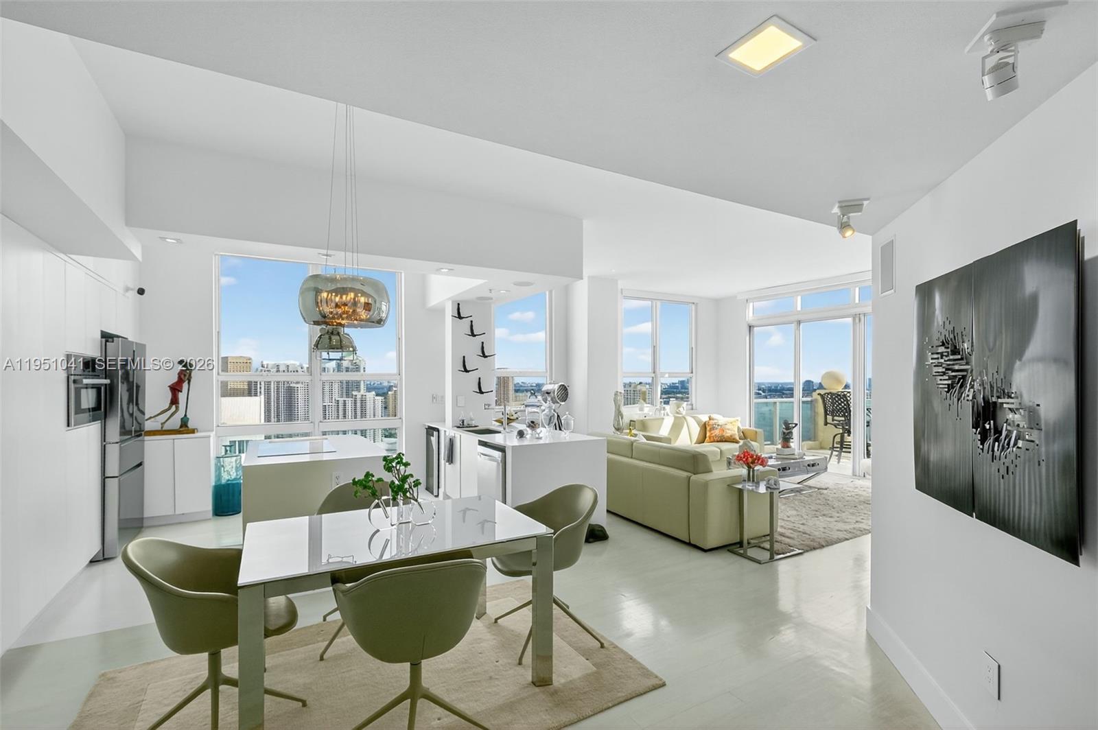 A modern open-concept living and dining area features white cabinetry, light flooring, and floor-to-ceiling windows — 1155 Brickell Bay Dr, Miami FL 33131, MIAMI, FL