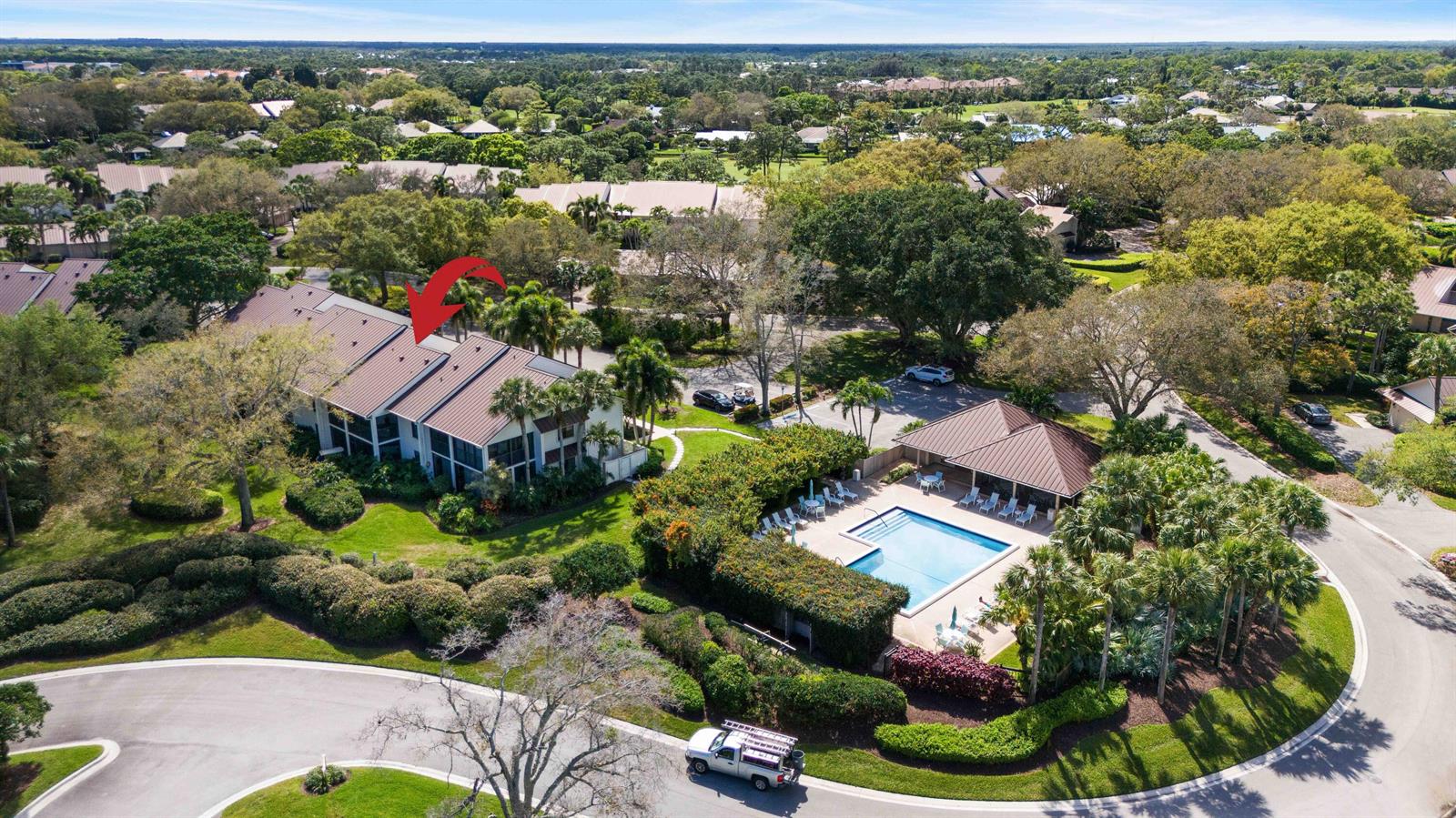 An aerial view shows a multi-unit residential building next to a community swimming pool — 6403 SE Brandywine Court # 223, Stuart FL 34997, STUART, FL