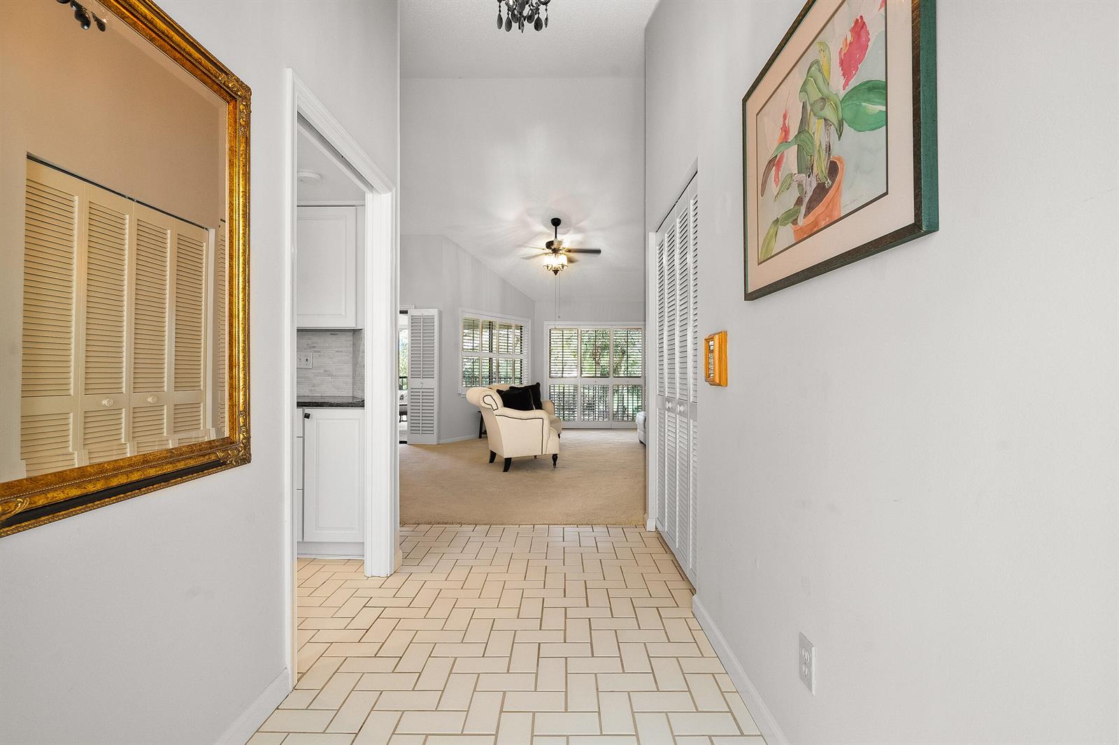 A tiled entryway leads into a carpeted living area with white walls and louvered closet doors — 6403 SE Brandywine Court # 223, Stuart FL 34997, STUART, FL