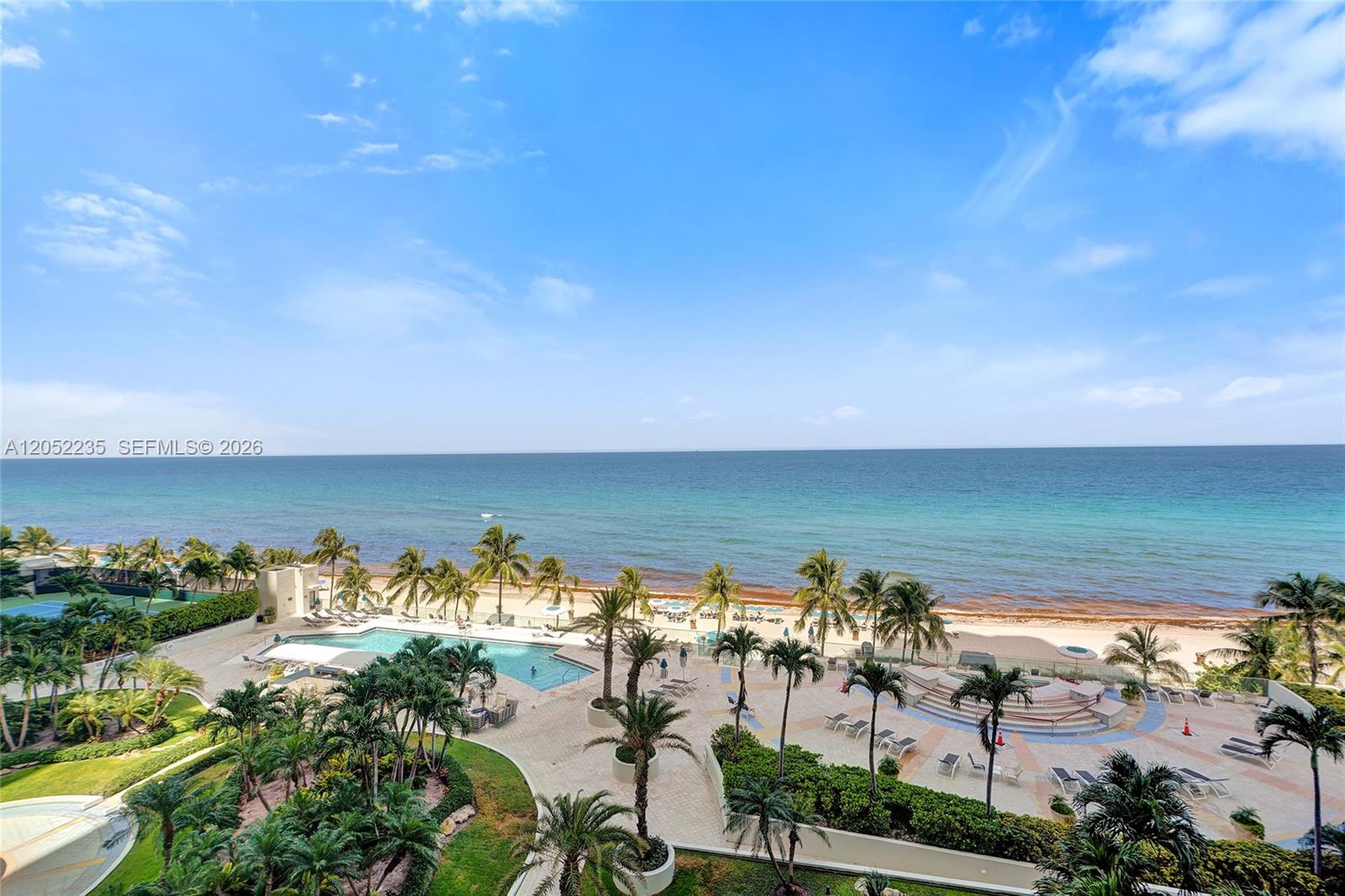 An elevated view shows a swimming pool, palm trees, and a beach along the ocean — 19111 Collins Ave # 607, Sunny Isles Beach FL 33160, SUNNY ISLES BEACH, FL