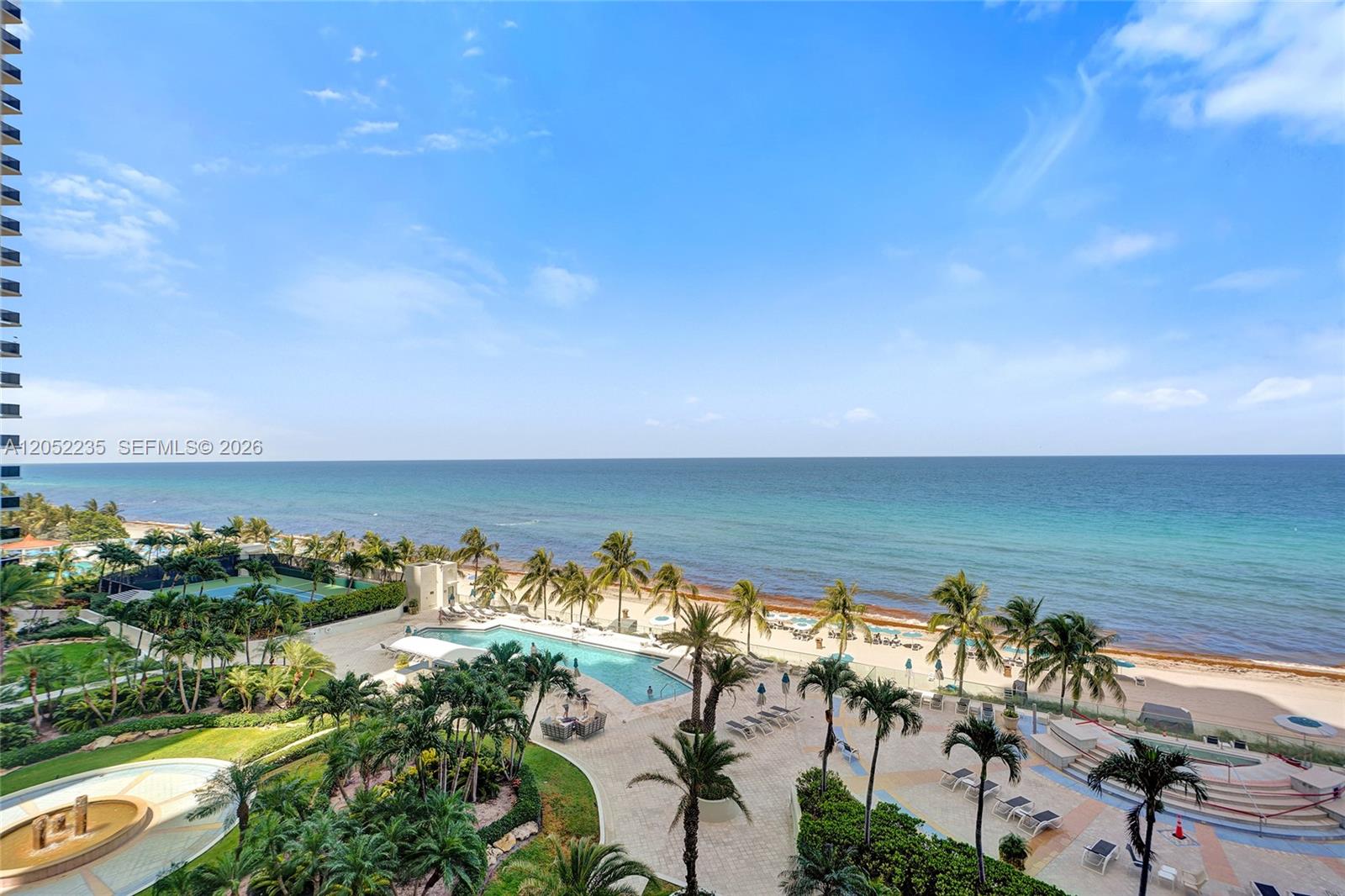 An elevated view shows a swimming pool, palm trees, and a beach along the ocean — 19111 Collins Ave # 607, Sunny Isles Beach FL 33160, SUNNY ISLES BEACH, FL