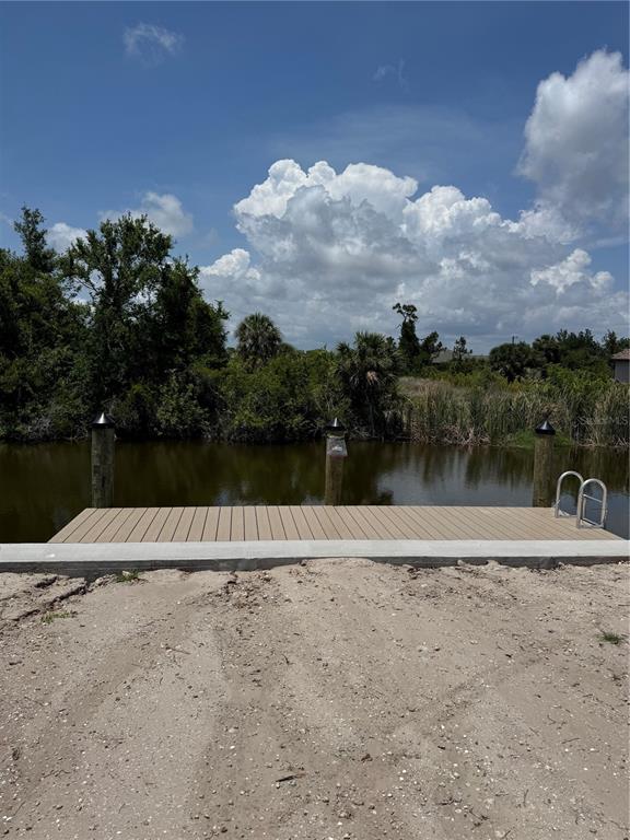A wooden dock with three pilings and a ladder sits beside a canal — 13156 AMARYLLIS CIRCLE, PORT CHARLOTTE, FL