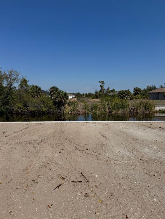 A vacant, sandy lot overlooks a narrow canal bordered by trees and shrubs — 13156 AMARYLLIS CIRCLE, PORT CHARLOTTE, FL