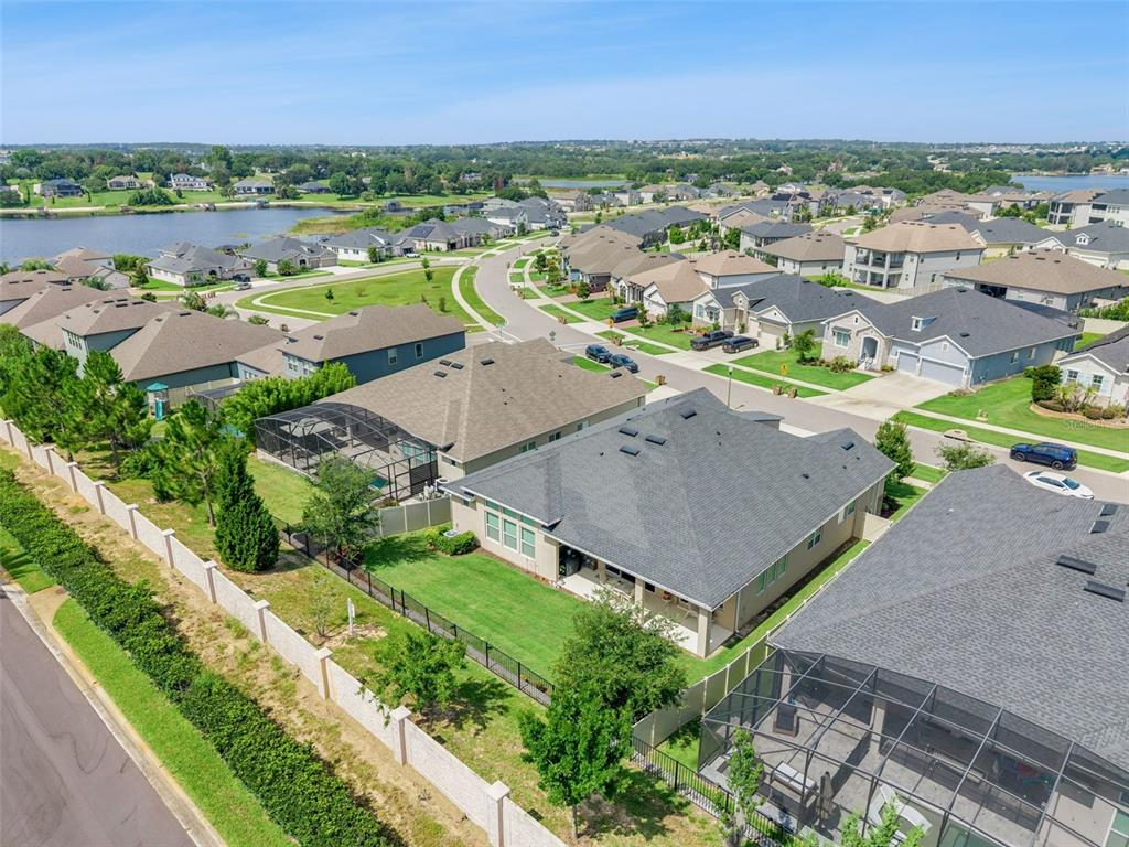 An aerial view of the rear exterior of a suburban house with a fenced backyard — 17286 HICKORY WIND DRIVE, CLERMONT, FL