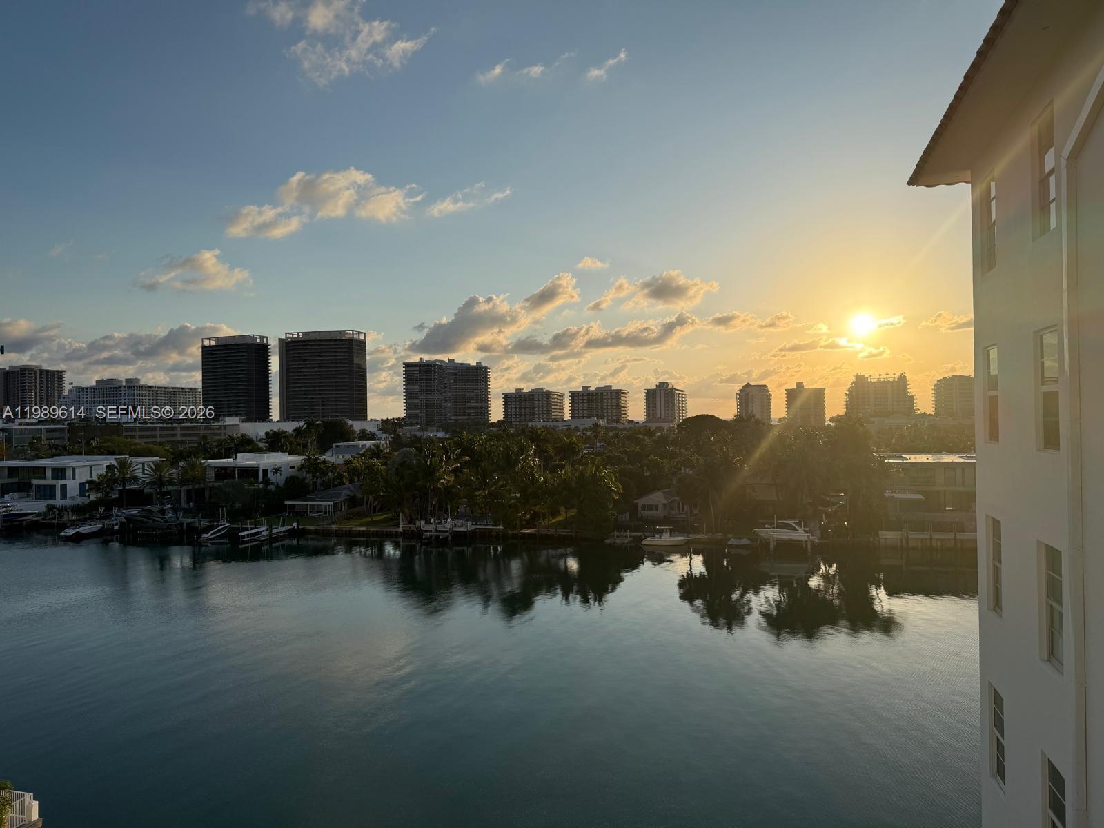 An elevated view of a waterfront canal with high-rise buildings under a sunset sky — 9341 E Bay Harbor Dr # 6C, Bay Harbor Islands FL 33154, BAY HARBOR ISLANDS, FL