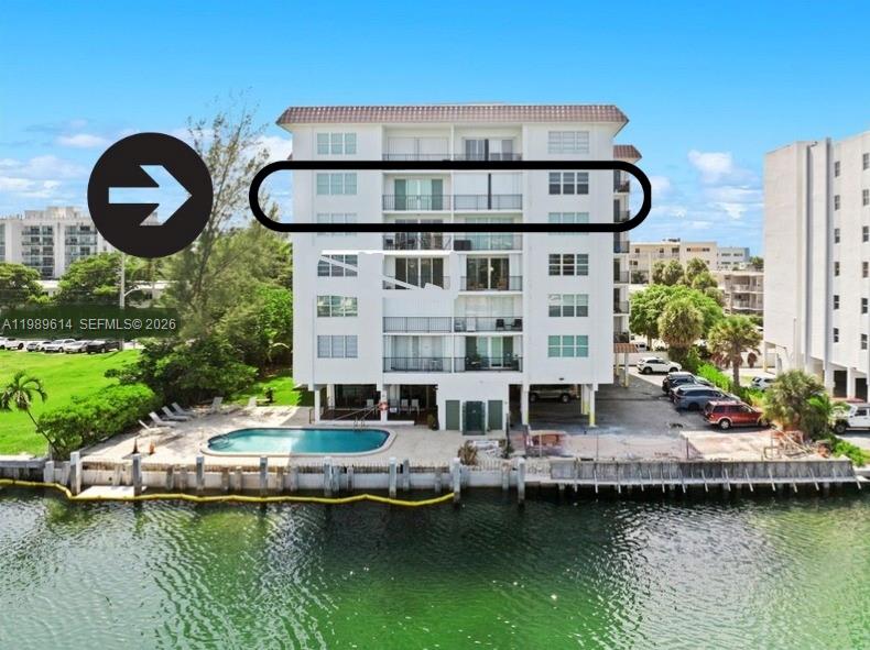 An exterior view of a multi-story waterfront apartment building with a pool and parking — 9341 E Bay Harbor Dr # 6C, Bay Harbor Islands FL 33154, BAY HARBOR ISLANDS, FL