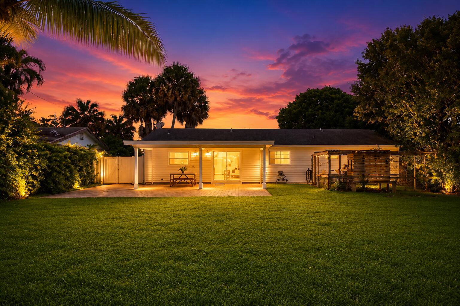 A white house with a covered patio and lawn at sunset with palm trees — 583 NW 12th Terrace, Boca Raton FL 33486, BOCA RATON, FL