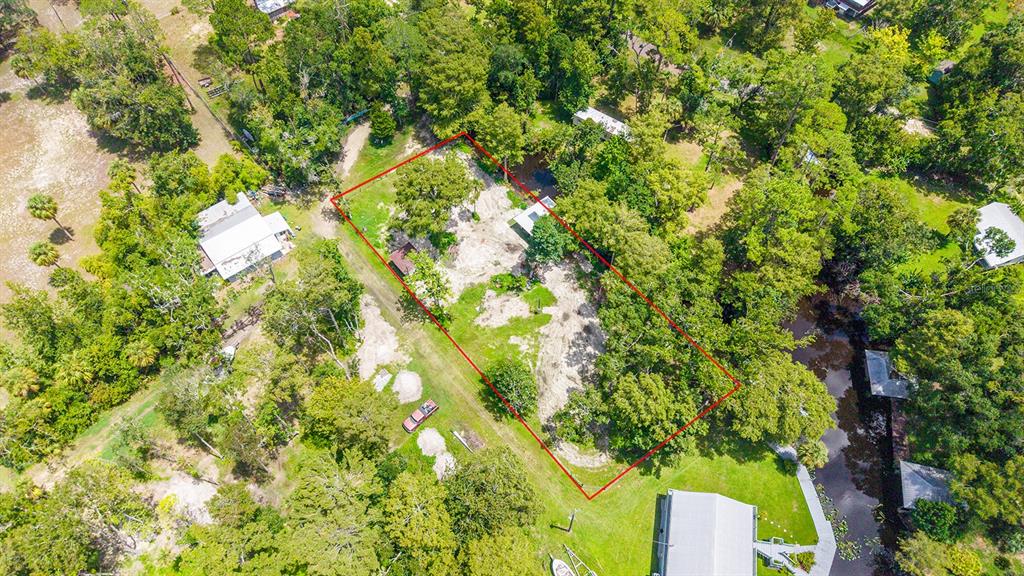 An aerial view shows a rectangular plot of land outlined in red amidst wooded surroundings — 000 SE 376TH STREET, SUWANNEE, FL