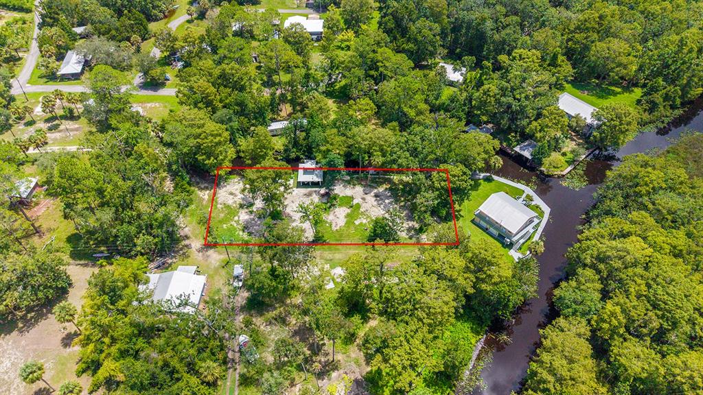 An aerial view shows a rectangular lot with trees and a small structure near water — 000 SE 376TH STREET, SUWANNEE, FL