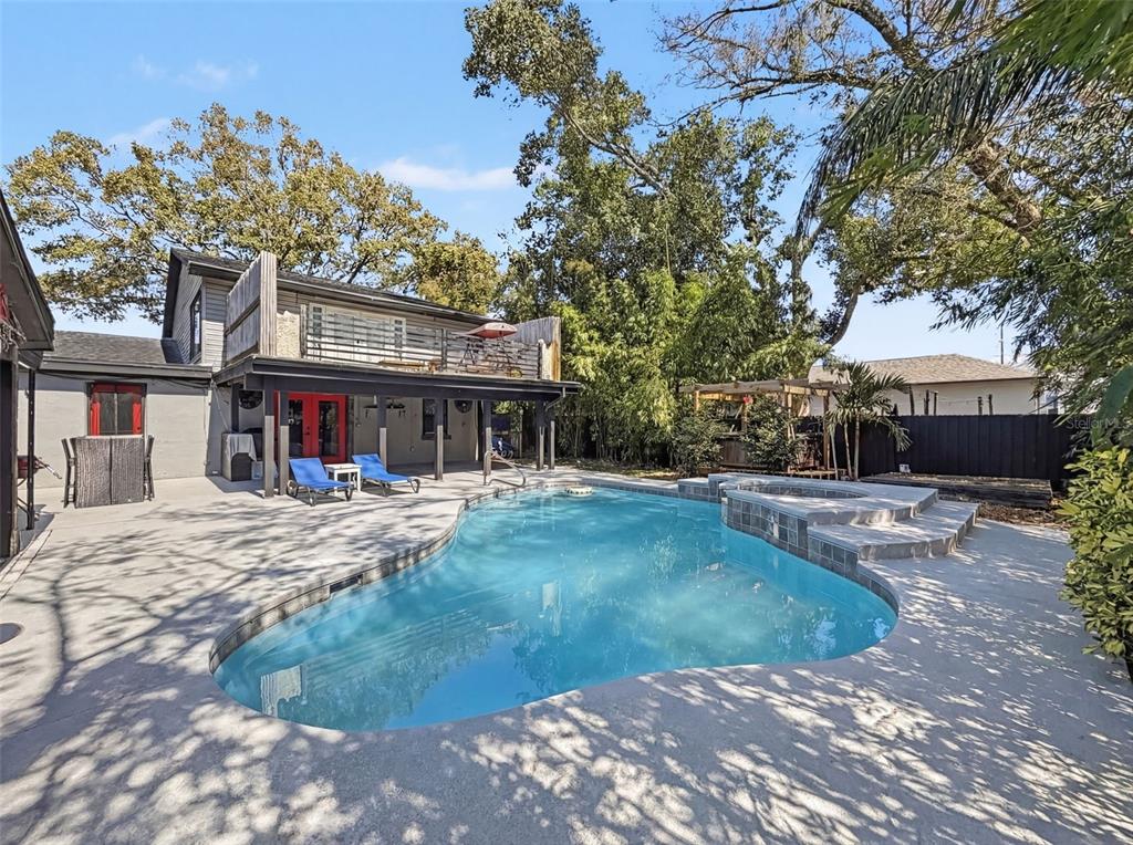 A backyard features a swimming pool with an attached spa, a patio, and a two-story house — 2206 HOWARD LANE, TAMPA, FL