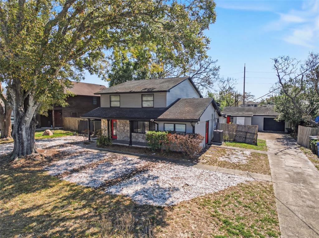 A two-story house with a stone facade, gray siding, and a large front yard — 2206 HOWARD LANE, TAMPA, FL