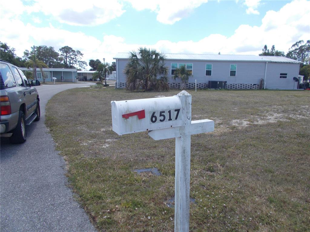 A white mailbox with the number 6517 stands in front of a light-colored mobile home — 6517 KIPA COURT, NORTH PORT, FL