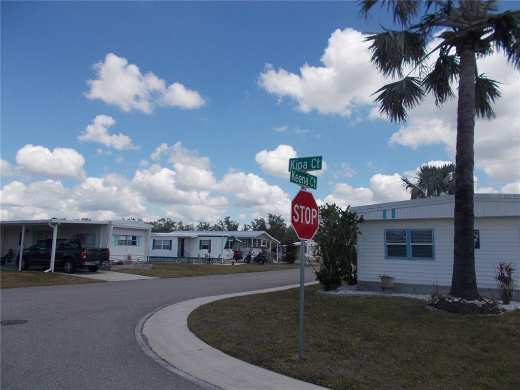 A street corner with a stop sign and street signs in a mobile home park — 6517 KIPA COURT, NORTH PORT, FL