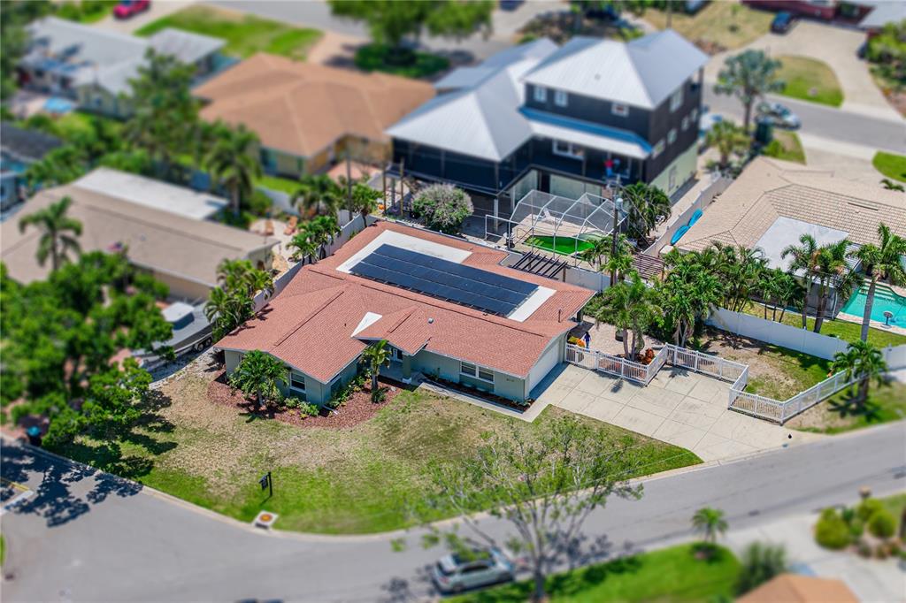 An aerial view shows a single-story house with solar panels on a brown shingled roof — 6717 CARDINAL DRIVE S, ST PETERSBURG, FL