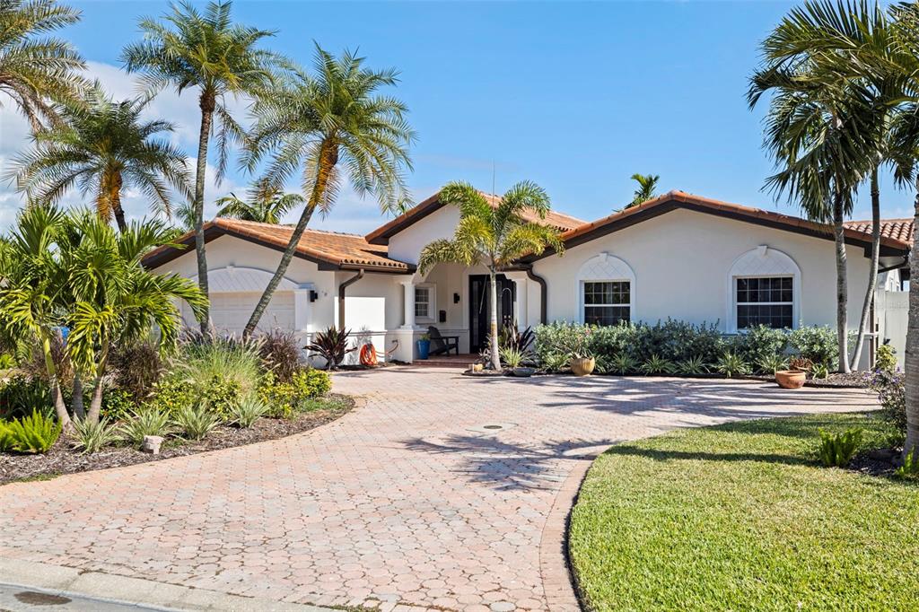 A single-story house with a tiled roof, white stucco exterior, and a paved circular driveway — 7827 9TH AVENUE S, ST PETERSBURG, FL