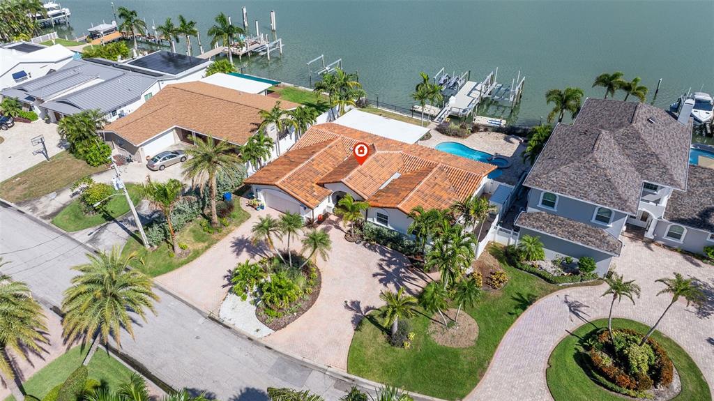 An aerial view shows a waterfront house with a tiled roof, pool, and boat dock — 7827 9TH AVENUE S, ST PETERSBURG, FL