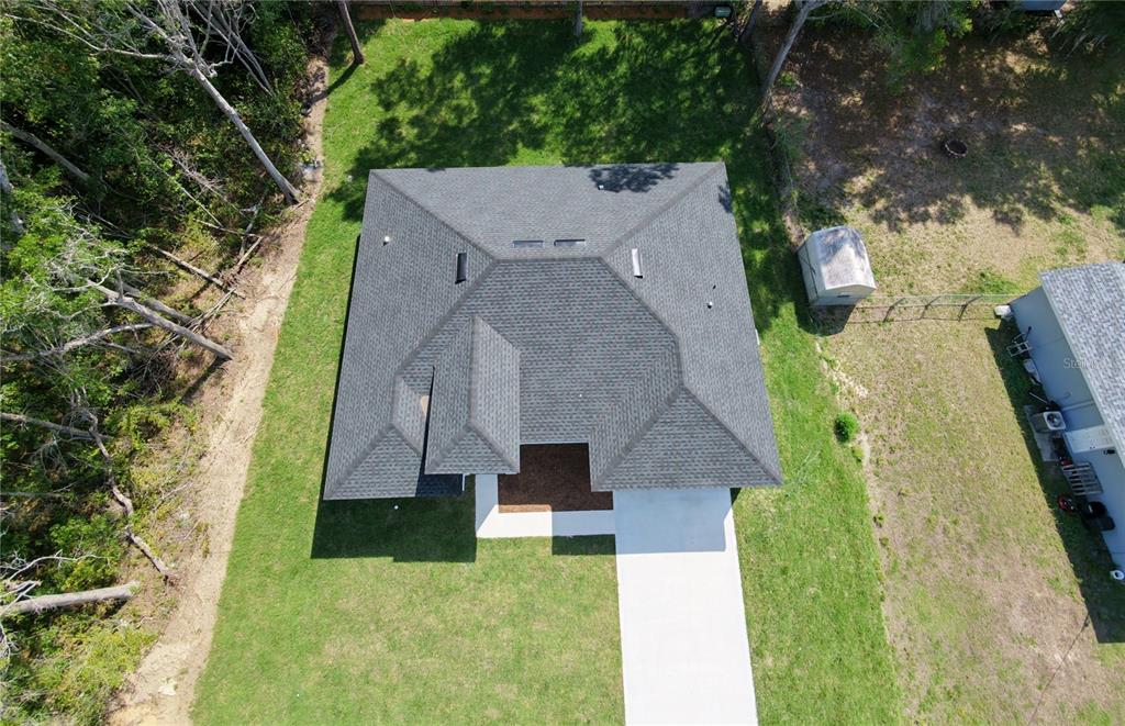 An aerial view shows a house with a gray shingled roof and a concrete driveway — 8839 N JOANN DRIVE, CITRUS SPRINGS, FL