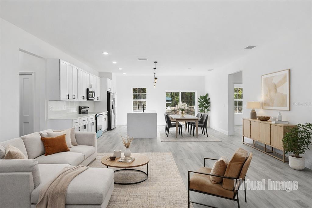 This virtual rendering shows an open-concept kitchen, dining area, and living room with white cabinetry — 8839 N JOANN DRIVE, CITRUS SPRINGS, FL