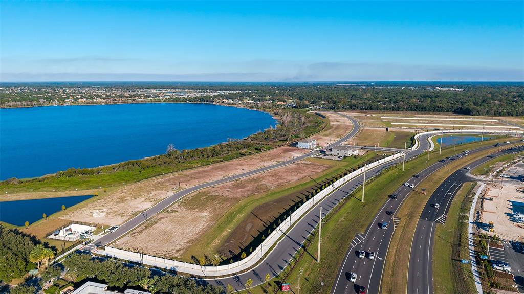 An aerial view shows a large lake adjacent to a cleared residential development site — 19313 LOCHSIDE LANE, MOUNT DORA, FL