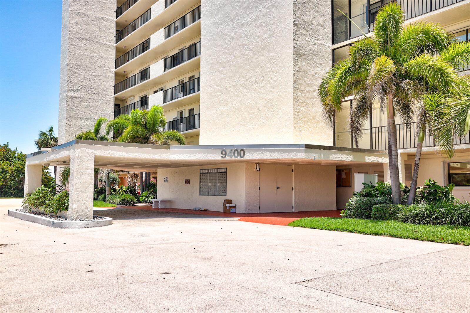 The exterior of a multi-story apartment building features a covered entrance with mailboxes — 9400 S Ocean Drive # 807, Jensen Beach FL 34957, JENSEN BEACH, FL