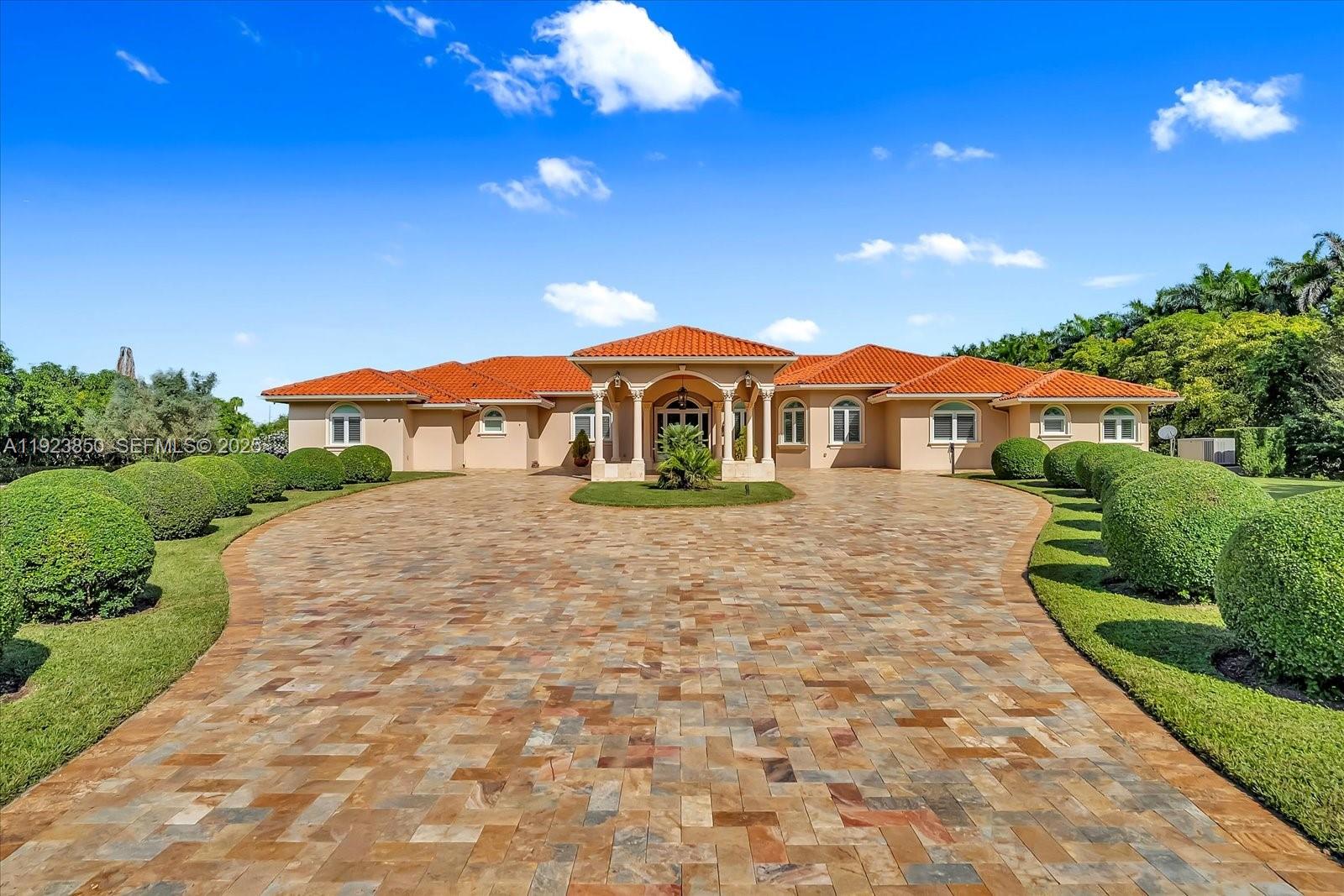 A single-story house with a terracotta tile roof and a large paved circular driveway — 18611 SW 122nd St, Miami FL 33196, MIAMI, FL