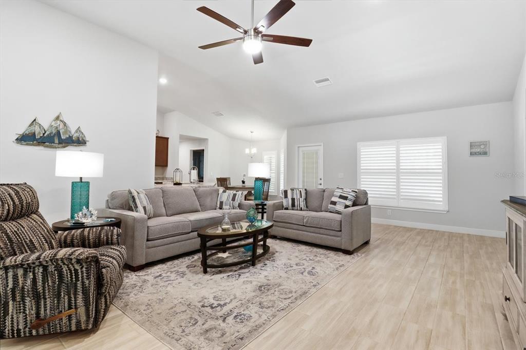 A living room features light tile floors, a ceiling fan, and gray upholstered furniture — 3 STOKESIA COURT, HOMOSASSA, FL