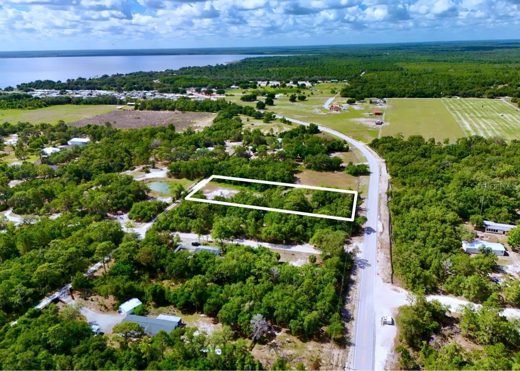 An aerial view shows a rectangular plot of land outlined in white beside a road — 3175 WALK IN WATER ROAD, LAKE WALES, FL