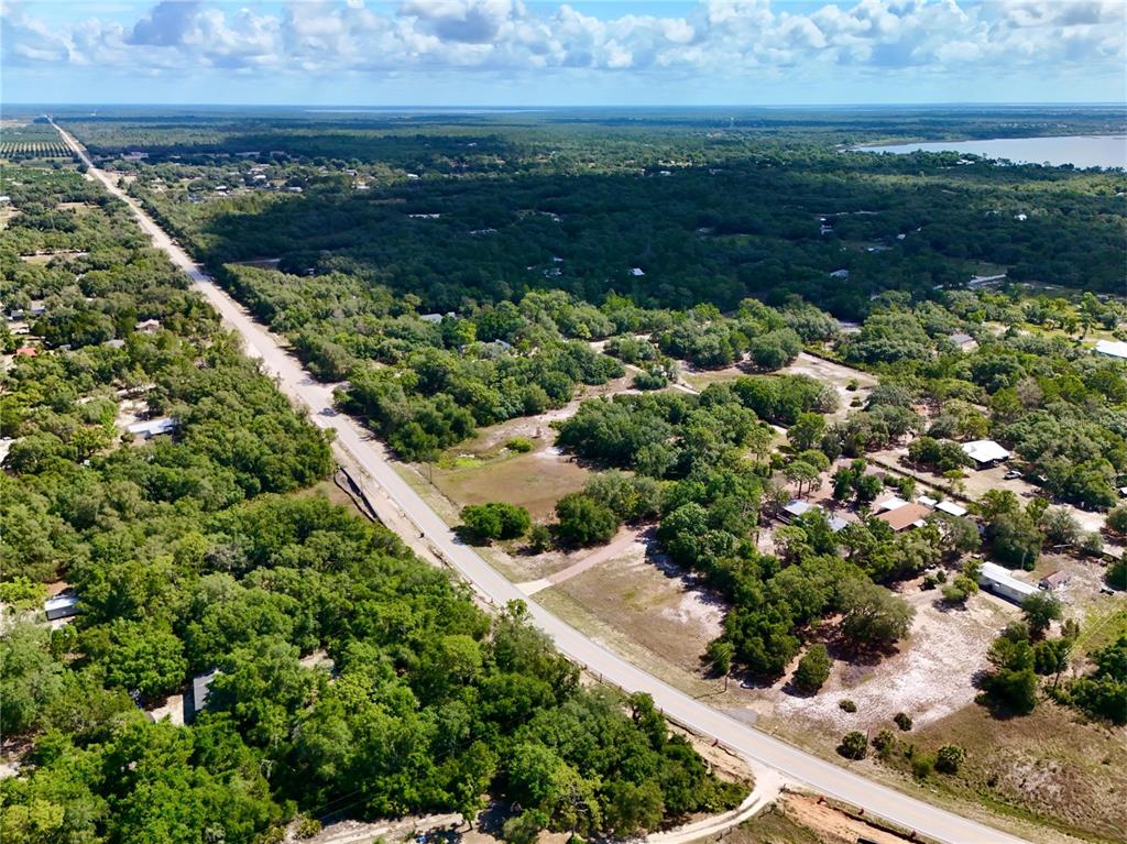 An aerial view shows a rural road winding through a wooded area with scattered houses — 3175 WALK IN WATER ROAD, LAKE WALES, FL
