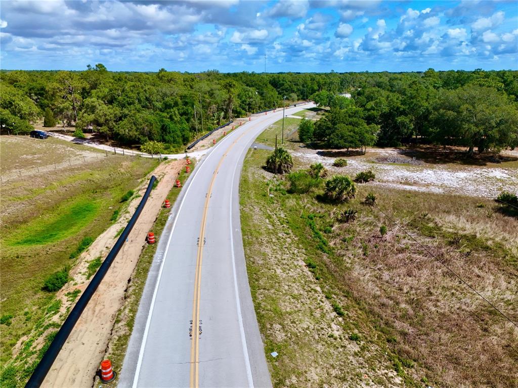 An aerial view shows a paved road winding through a rural, wooded landscape — 3175 WALK IN WATER ROAD, LAKE WALES, FL