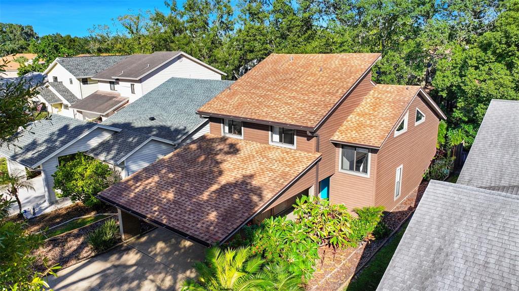 An aerial view of a brown two-story house with a shingled roof and carport — 3576 RAINTREE WAY, LAKELAND, FL