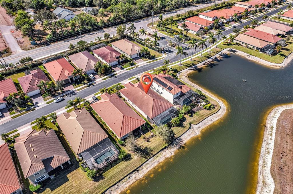 An aerial view shows a suburban neighborhood with houses, a lake, and a red pin — 11542 BLACKFIN STREET, VENICE, FL