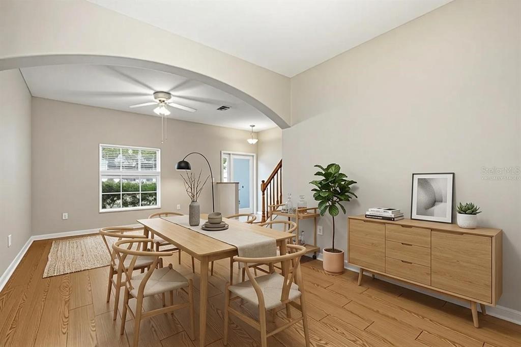 A dining room with light wood furniture, a beige area rug, and an arched entryway — 18318 HOLLAND HOUSE LOOP, LAND O LAKES, FL