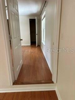 A view through an open doorway into a room with wood-look flooring and a window — 248A S CLAYTON STREET Apt A, MOUNT DORA, FL
