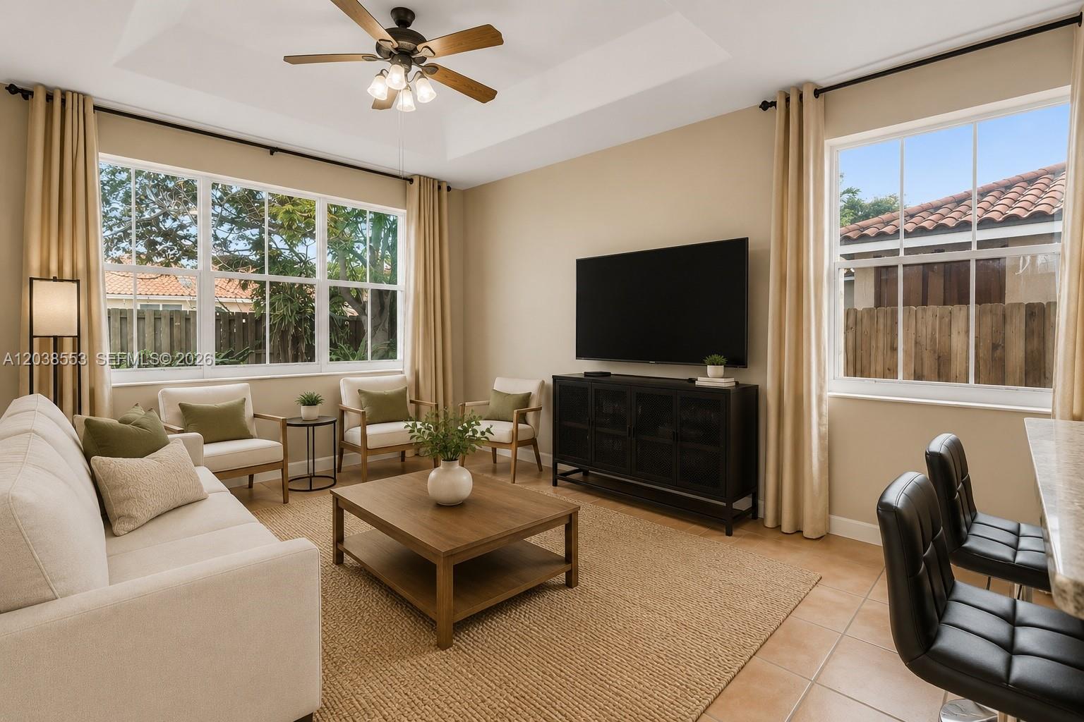 A living room features a sofa, coffee table, armchairs, television, and tile flooring — 16728 SW 36th St, Miramar FL 33027, MIRAMAR, FL