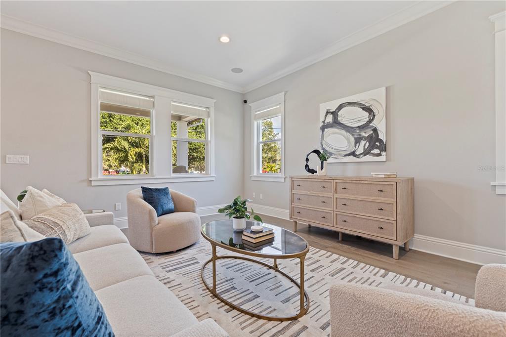 A living room features a sofa, two armchairs, a glass coffee table, and a wooden dresser — 1001 CORDOVA BOULEVARD NE, ST PETERSBURG, FL