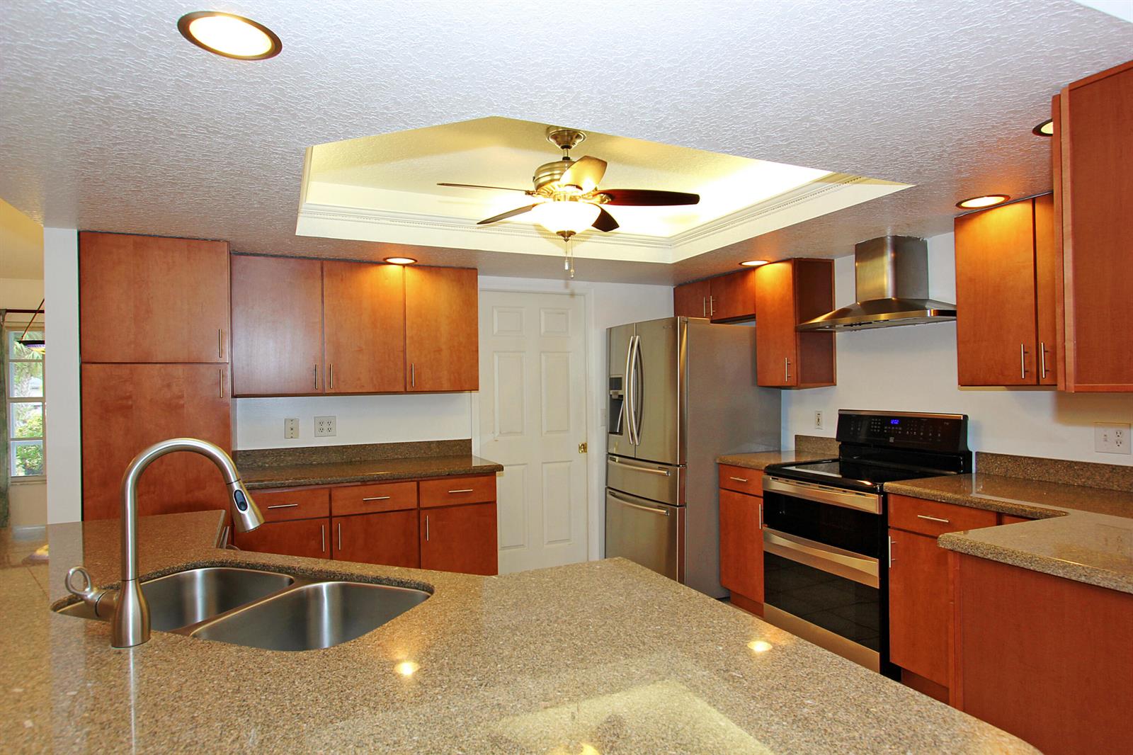 A kitchen with wood cabinets, granite countertops, stainless steel appliances, and a ceiling fan — 16655 N 113th Trl Trail N, Jupiter FL 33478, JUPITER, FL