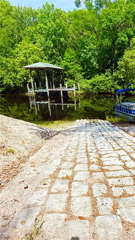 A stone boat ramp leads to a covered boat dock on a tree-lined waterway — 2905 CREEK STREET, MIDDLEBURG, FL