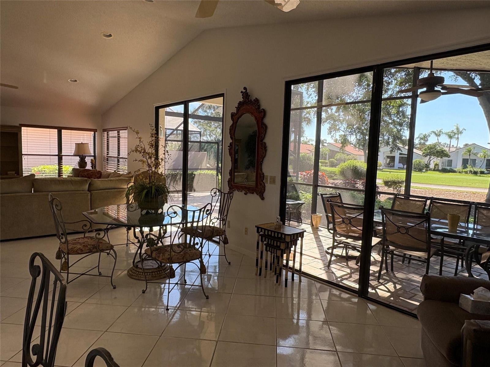 A dining area with tile floors and glass doors opening to a screened-in patio — 7744 Dundee Lane, Delray Beach FL 33446, DELRAY BEACH, FL
