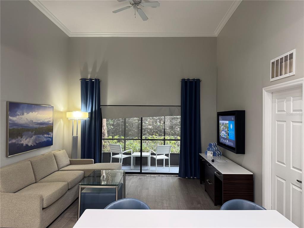 A living room features a sectional sofa, a glass coffee table, and a sliding glass door — 14501 GROVE RESORT AVENUE UNIT 1110, WINTER GARDEN, FL