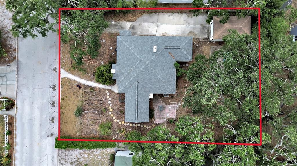 An aerial view shows a house with a gray roof, a driveway, and trees — 235 38TH STREET S, ST PETERSBURG, FL