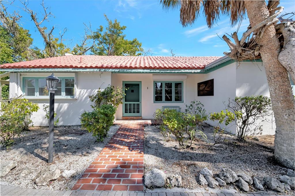 A single-story house with a red tile roof, white stucco walls, and a brick walkway — 4237 HIGEL AVENUE, SARASOTA, FL