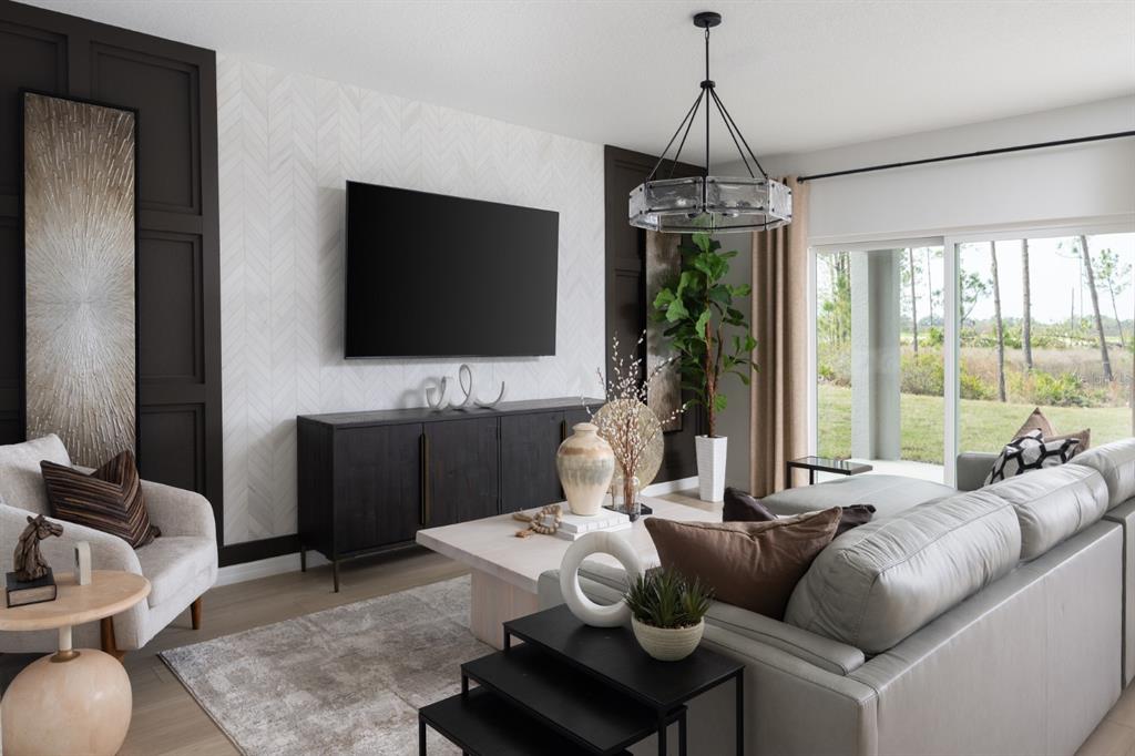 A modern living room features a herringbone accent wall, dark cabinetry, and a large sectional — 9284 JOYFUL HEIGHTS WAY, DADE CITY, FL