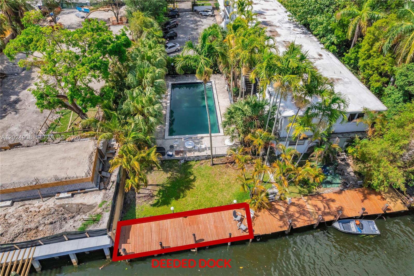 An aerial view shows a wooden dock extending into a canal behind a residential property — 645 NE 77th St # 1, Miami FL 33138, MIAMI, FL